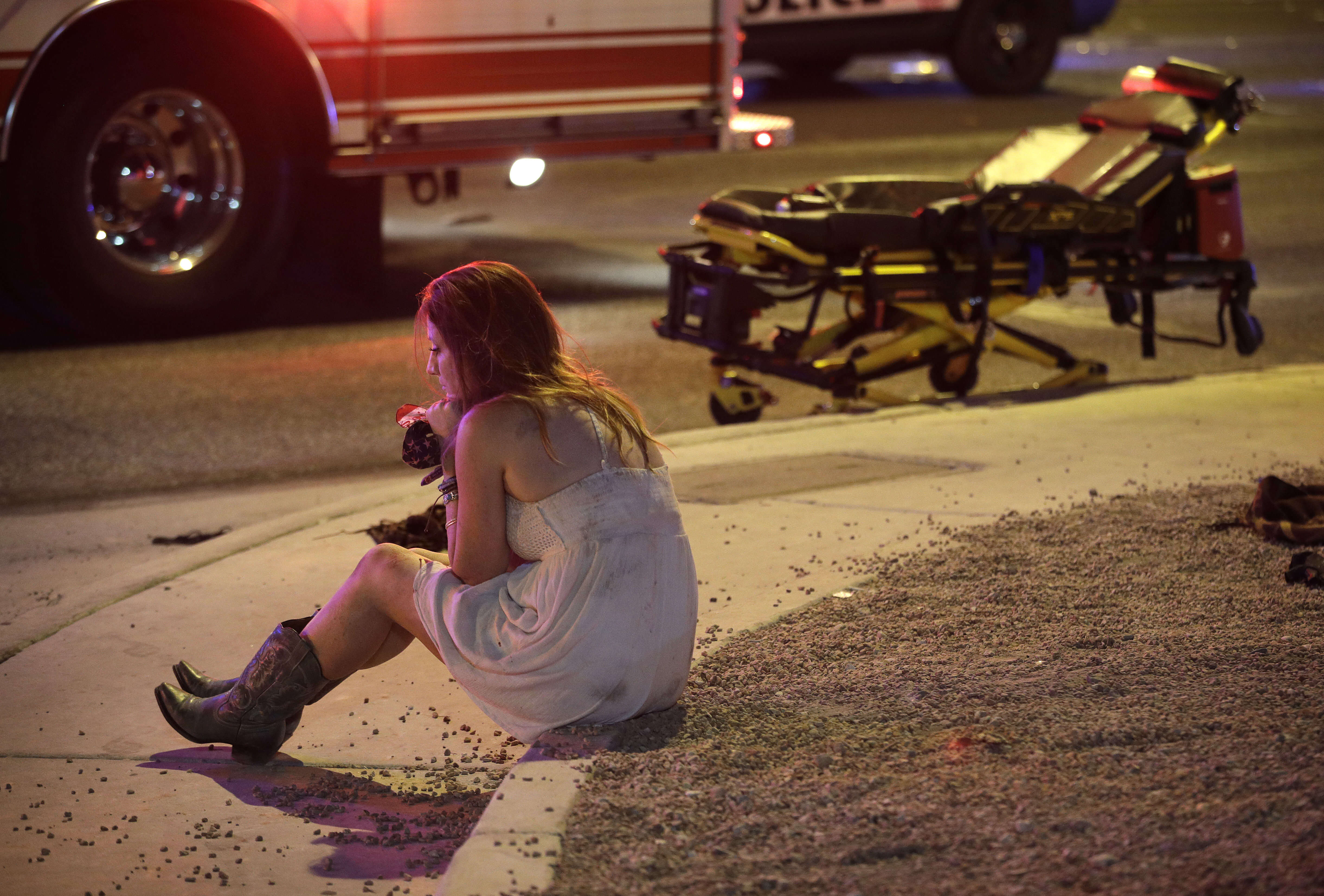 Une femme est assise, à Las Vegas, sur un trottoir près des lieux où une fusillade a été perpétrée depuis un hôtel de la ville contre des festivaliers. L’attaque, attribuée à un retraité américain, Stephen Paddock, a fait 58 morts et plusieurs centaines de blessés.