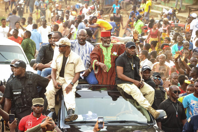 L’ancien chef de guerre Prince Johnson (R) saluant ses partisans sur le toit d’une voiture avec le candidat présidentiel libérien George Weah, qu’il avait approuvé , à Monrovia, le 27 octobre à Monrovia.