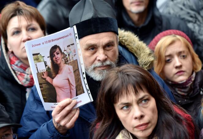 Un prêtre orthodoxe tenant une photo d’Iryna Nozdrovska lors d’un rassemblement à sa mémoire, à Kiev le 2 janvier.