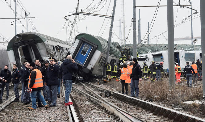 Des officiers de secours et de police se tiennent près du train qui a déraillé à Pioltello, dans la banlieu de Milan, le 25 janvier 2018.