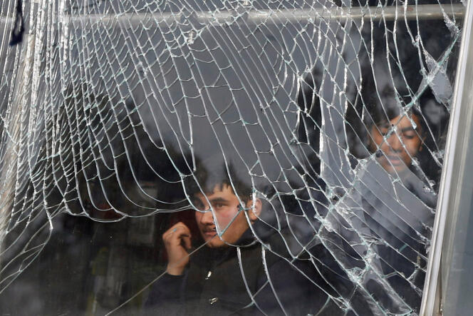 Un boutiquier derrière la vitrine cassée de son échoppe, à Kaboul, le 27 janvier.