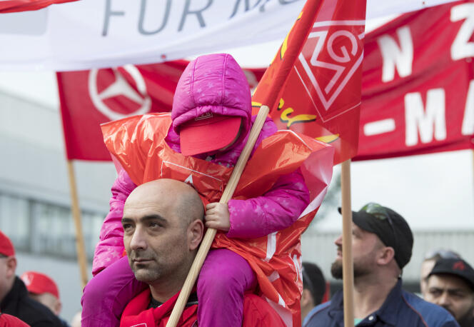 Un employé d’EvoBus, une filiale de Daimler, avec sa fille, lors d’une grève d’avertissement à l’appel du syndicat IG Metall à Mannheim, dans le sud-ouest de l’Allemagne, le 11 janvier 2018.