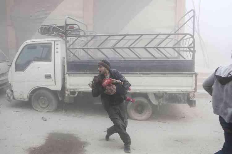 Un homme avec un enfant dans les bras, après un bombardement, le 6 février.