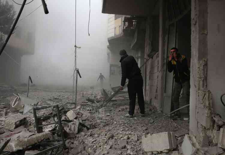 Des membres de la défense civile syrienne cherchent des victimes blessées dans les décombres, à Hamouria, le 20 février.
