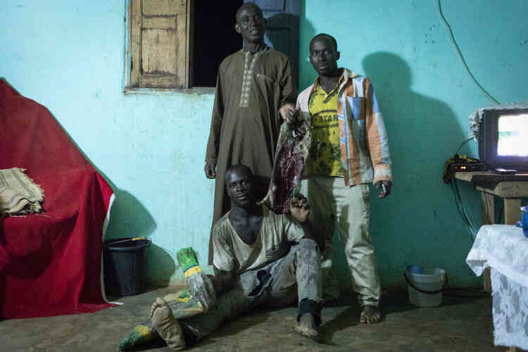 Vendredi 2 février. Le grand-oncle de Kader, Bangali (debout à gauche), et deux chasseurs guinéens. Ils viennent de chasser un agouti (rongeur) pour célébrer l’arrivée de Kader.