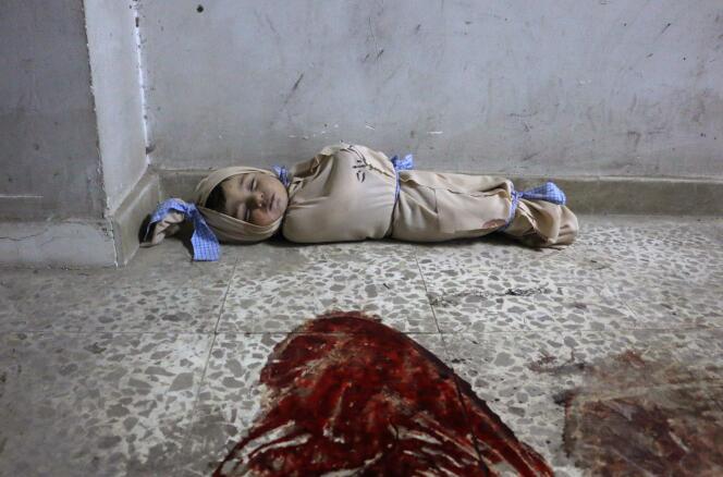 Le corps d’un bébé enveloppé dans un linceul repose dans un dispensaire de fortune, à Douma, dans la Ghouta orientale bombardée, le 22 février.