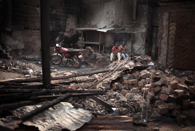 Des Centrafricains assis dans les ruines du marché du quartier musulman de Bangui après un violent incendie le 17 janvier.