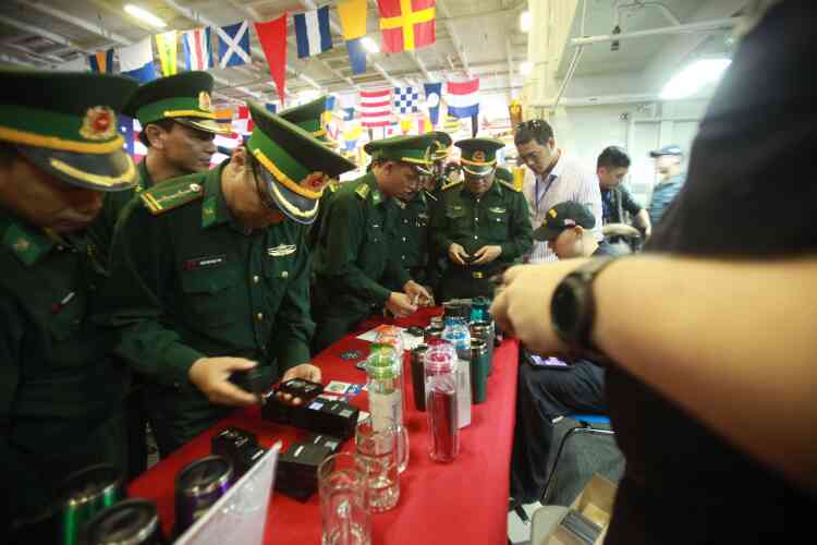 Des officiers militaires vietnamiens achètent des souvenirs lors de leur visite du porte-avions. Les liens militaires entre les deux anciens ennemis se sont renforcés ces dernières années, notamment depuis une visite historique en 2016 de l’ex-président américain Barack Obama, qui avait levé un embargo sur les ventes d’armes à Hanoï.