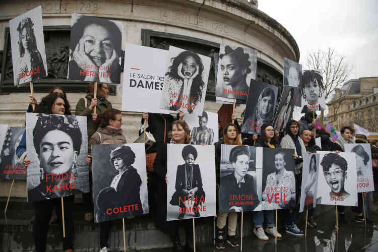 Des femmes tiennent des affiches de féministes célèbres lors du rassemblement à Paris, le 8 mars. Les statistiques montrent qu’à âge égal et à emploi équivalent, il y a un écart de 9 % entre les salaires des hommes et des femmes en France.