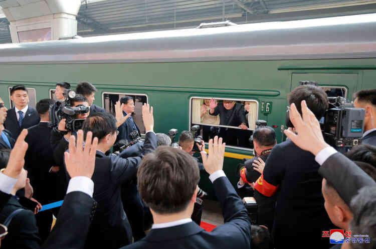 Kim Jing-un et son épouse saluant la délégation chinoise alors que leur train quitte le quai, mardi 27 mars.