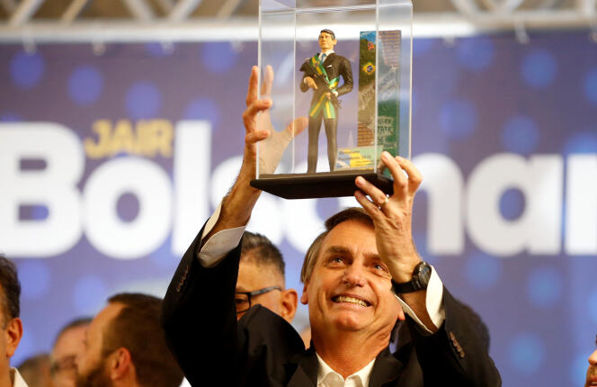 Jair Bolsonaro montre une poupée à son effigie lors d’un meeting à Curitiba, le 29 mars 2018.
