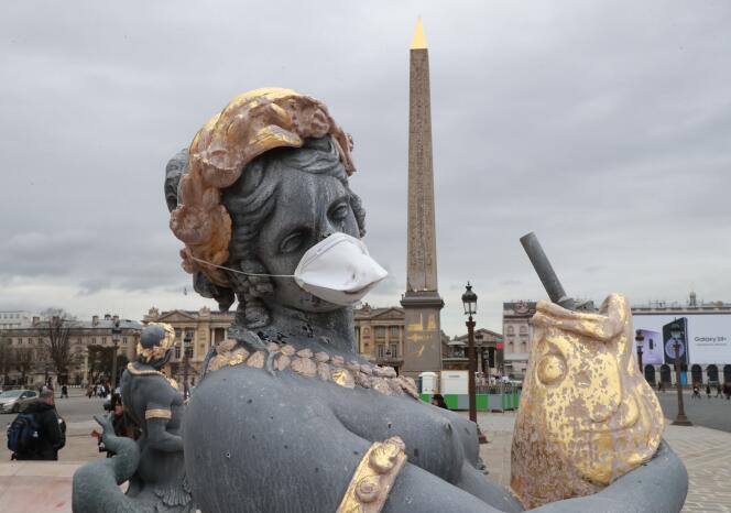 Place de la Concorde, des associations de défense de l’environnement ont posé des masques sur les statues, samedi 31 mars, à Paris.