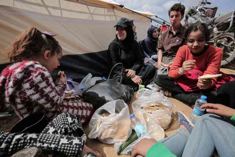 Des manifestants palestiniens mangent à côté de tentes dressées pour ce rassemblement, vendredi 30 mars.
