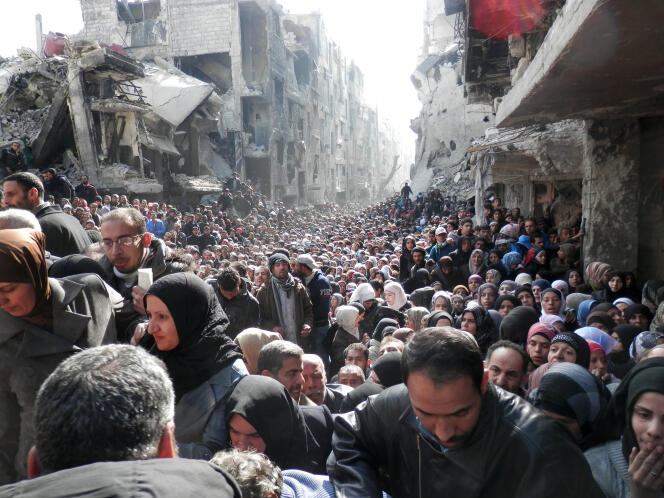 Distribution de rations alimentaires, à Yarmouk, en janvier 2014. La ville est assiégée par les forces syriennes, depuis l’été 2013.
