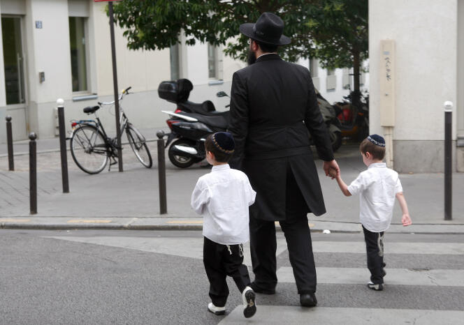 Un homme juif tenant la main à deux enfants, le 4 juillet 2009, à Paris.