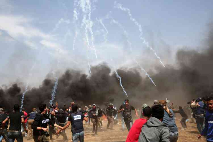 Des manifestants fuient les multiples gaz lacrymogènes tirés par les forces de sécurité israéliennes près de Khan Younès.