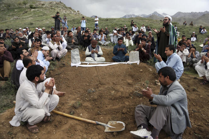 Des proches, des collègues et des amis prient près de la tombe de Shah Marai, chef photographe de l’AFP à Kaboul, tué dans un double attentat suicide qui a frappé la capitale tôt lundi.