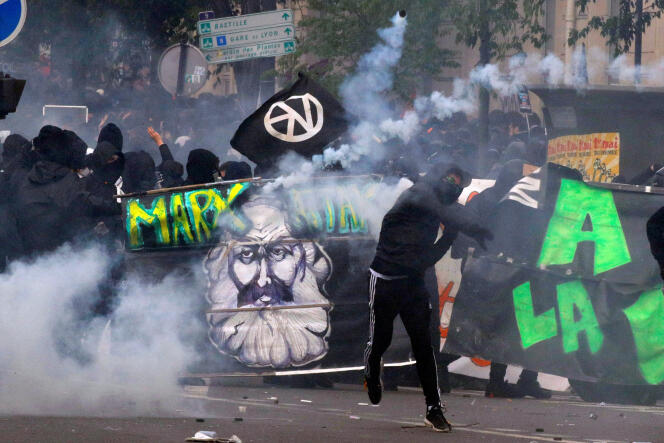 Des manifestants masqués affrontent les forces de l’ordre, à Paris, le 1er mai.