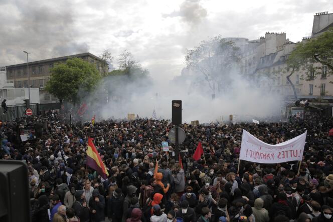 Les manifestants se déplacent dans un nuage de gaz lacrimogène, lors du défilé du 1er mai, à Paris.