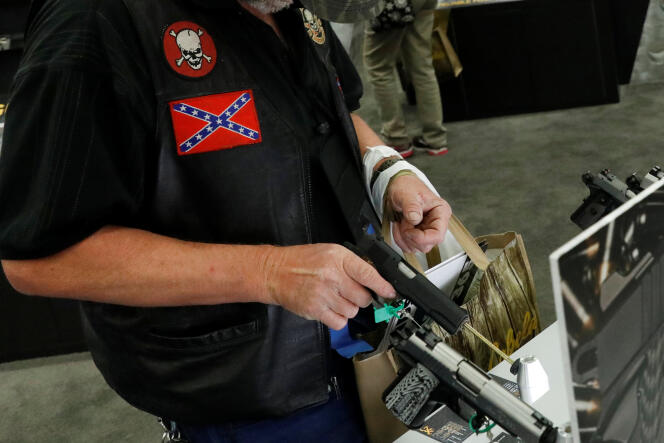 Un homme inspecte un pistolet lors d’une convention de la NRA, à Dallas (Texas), en mai 2018.