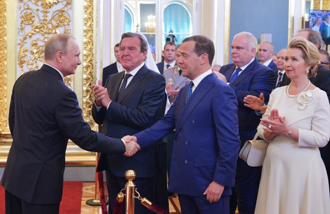Le président russe Vladimir Poutine serrant la main de Dmitry Medvedev, en présence de l’ancien chancelier allemand Gerhard Schröder, et la femme de M. Medvedev, à Moscou, le 7 mai.