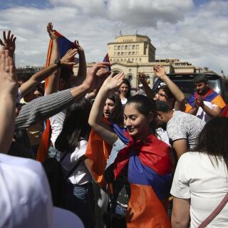People dance at the Republic Square in Yerevan, Tuesday, May 8, 2018. Tens of thousands of supporters of Nikol Pashinian are celebrating on the central square of Armenia's capital after the protest leader was elected the country's prime minister. (AP Photo/Thanassis Stavrakis)