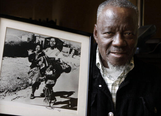 Le 27 avril 2011, le photographe Sam Nzima pose devant sa photographie montrant un jeune écolier noir, mortellement blessé par la police de l’apartheid durant le soulèvement de Soweto en 1976.