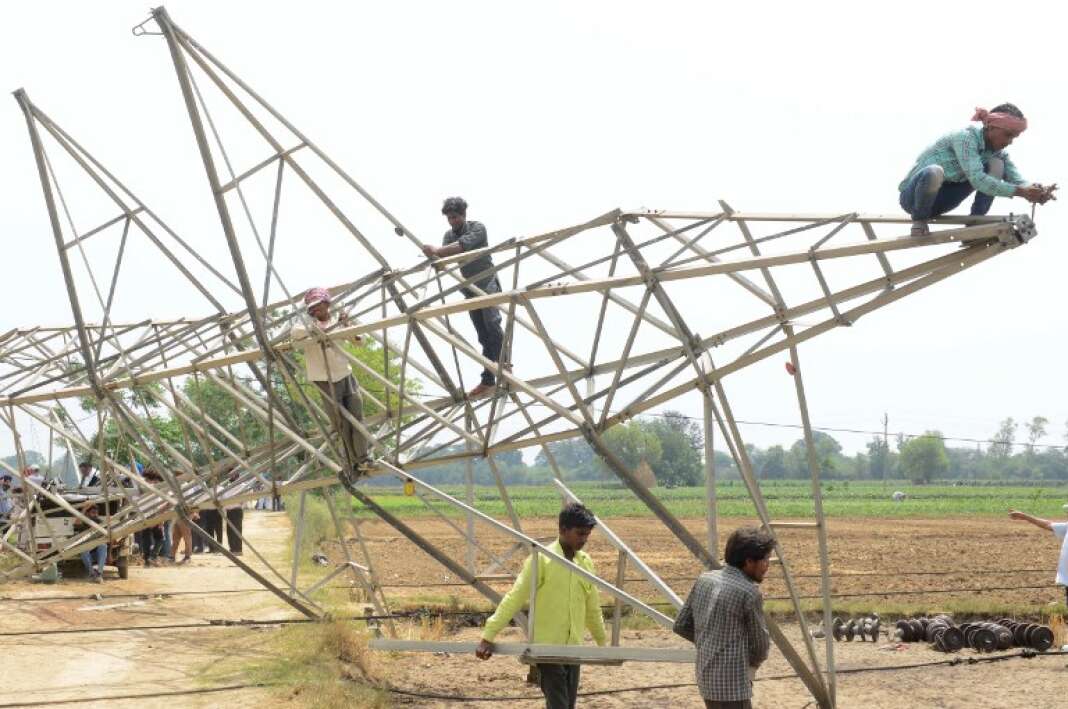 Des travailleurs enlèvent un pylône électrique tombé à terre dans la tempête du 12 mai, près de la ville d’Amritsar, dans l’Etat du Pendjab (dans le nord du pays).