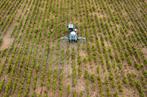 LOIC VENANCE / AFP An aerial picture taken on April 26, 2018 shows a farmer spraying chemicals to treat vineyard in Vertou, outside Nantes, western France. / AFP / Loic VENANCE