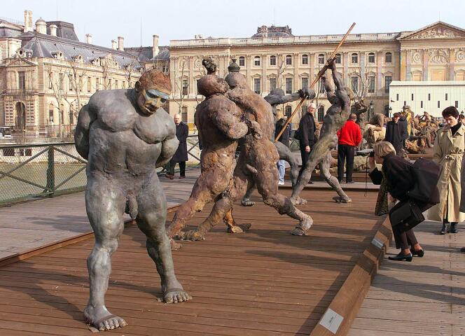 Des touristes et des Parisiens regardent, le 19 mars 1999 sur le pont des Arts à Paris, les sculptures du Sénégalais Ousmane Sow.