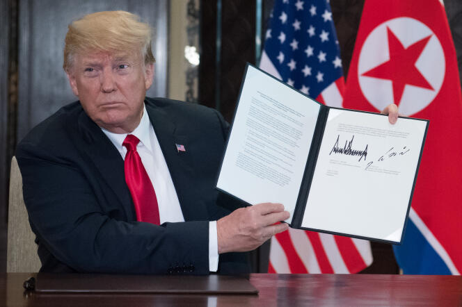 Donald Trump montrant l’accord qu’il vient de signer avec le leader nord-coréen, Kim Jong-un, à Singapour, le 12 juin.
