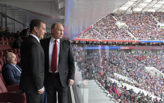 Avec son premier ministre, Dmitri Medvedev, lors du match d’ouverture Russie-Arabie saoudite, à Moscou, le 14 juin.