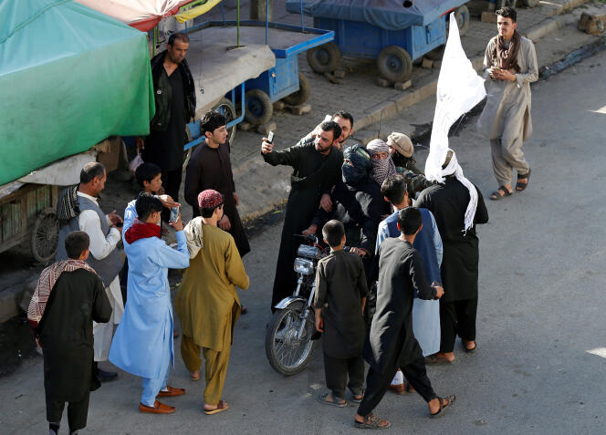 Des Afghans se prennent en photo avec des talibans pour célébrer le cessez-le-feu, le 16 juin à Kaboul.