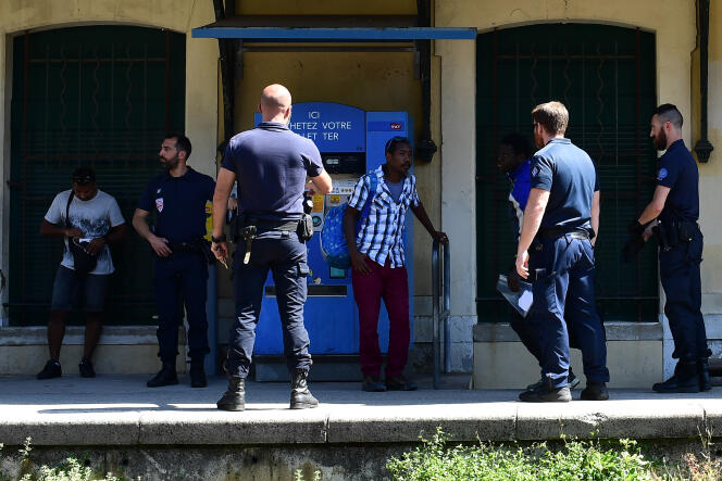 Des CRS contrôlent des migrants, à la gare de Menton, près de la frontière franco-italienne, le 14 juin.