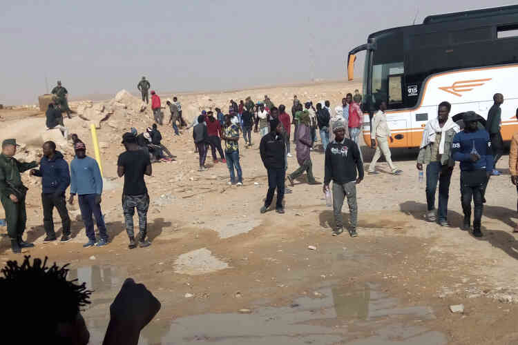 Sur cette photo datée du mardi 8 mai et fournie par le migrant libérien Ju Dennis, des migrants expulsés d’Algérie débarquent d’un bus dans le désert.