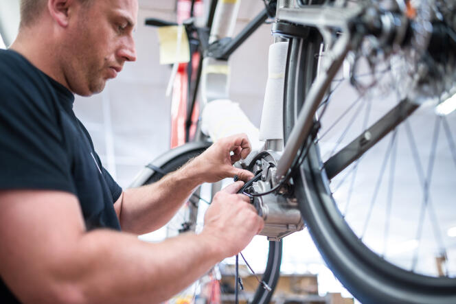 Câblage d’un moteur de vélo à assitance électrique chez Moustache Bikes à l’usine de Golbey (Vosges) en 2017