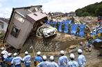 Les secours recensent les personnes disparues et viennent en aide aux habitants dont les maisons ont été détruites lors des intempéries, à Hiroshima, au Japon, le 9 juillet 2018.