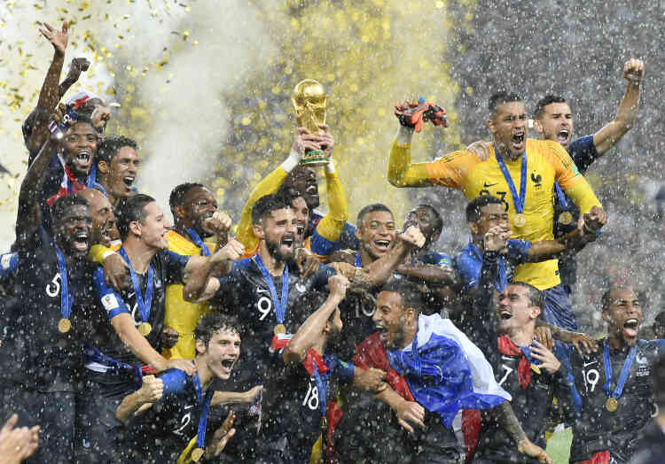Sous une pluie battante, l’équipe française pose avec le trophée. Le gardien de but Hugo Lloris soulève la coupe en l’air après leur victoire 4 à 2 sur la Croatie.