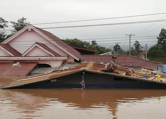 Un villageois trouve refuge sur un toit alors que la province d’Attapeu, dans le sud-est du Laos, est très fortement inondée, le 24 juillet.
