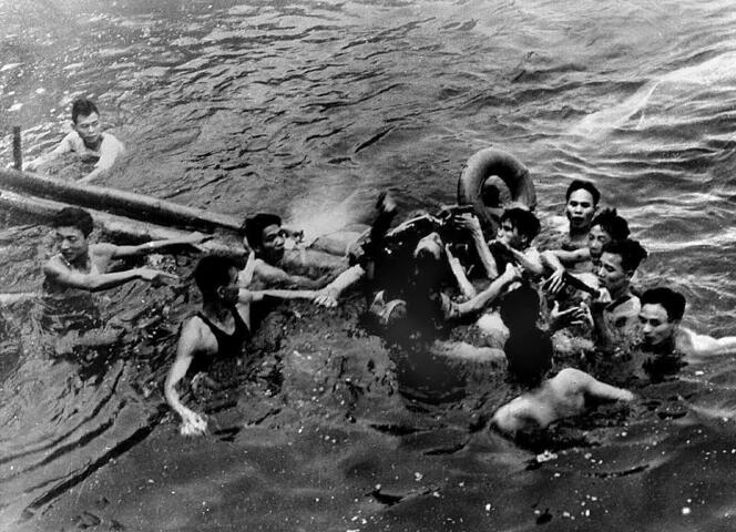 Photo prise le 26 octobre 1967 montrant le major John McCain (C) de l’US Navy sauvé dans le lac Truc Bach de Hanoï par plusieurs habitants de la capitale du Nord-Vietnam après que son avion de guerre ait été abattu.