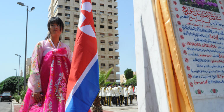 A young woman holds a North Korean flag during the inauguration ceremony of a park in the Syrian capital Damascus to honour North Korea's founding father Kim Il-Sung on August 31, 2015. The 9,000-square-metre park (about 2.2 acres) lies in the southwestern Damascus district of Kafr Sousa, atop the ruins of recently bulldozed homes. AFP PHOTO / STR / AFP PHOTO / -