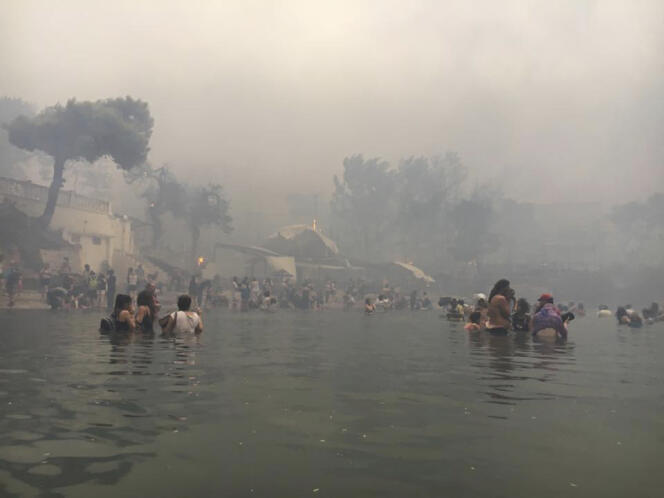 Des habitants tentent d’échapper aux flammes en restant dans la mer, à Mati, le 23 juillet.