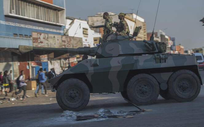 Un blindé fait fuir les partisans de l’opposition, à Harare (Zimbabwe), le 1er août.