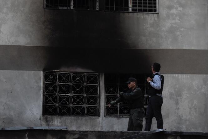 Les forces de sécurité inspectent un immeuble sur laquelle on voit des traces d’explosion, le 4 août à Caracas.