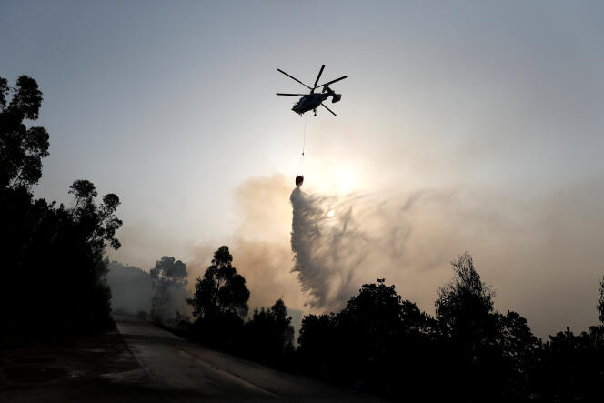 Un hélicoptère déverse de l’eau sur un incendie, à Monchique, au Portugal, le 6 août.