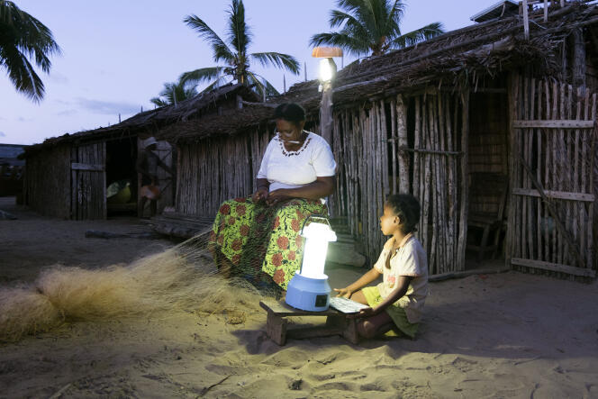 Yollande Randrianambinina recoud un filet de pêche à la lumière d’une lampe fonctionnant grâce à l’énergie photovoltaïque, le 23 avril à Ambakivao.