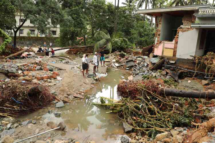 Des habitants de Kannappankundu constatent les dégâts d’une inondation soudaine, le 10 août.