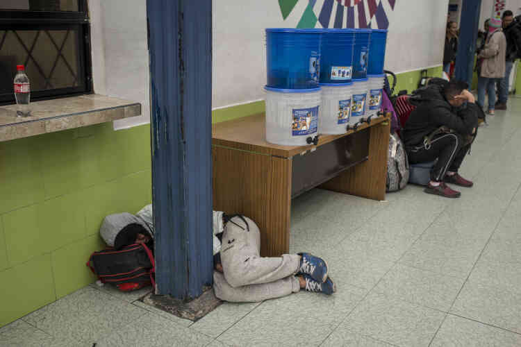 Un voyageur dort sur le sol près des services de migration équatoriens.
