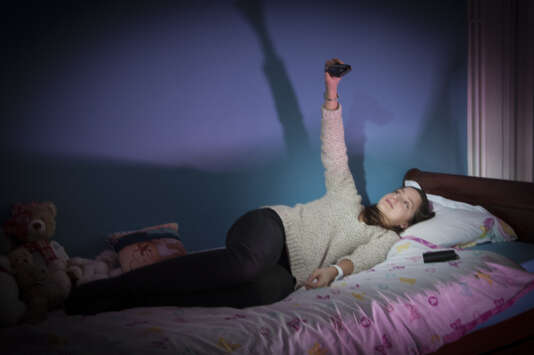 Adolescente dans sa chambre et sur son lit avec son appareil photo et ses peluches. Extrait de la  série « L’Antre de la jeunesse » (2015-2017).