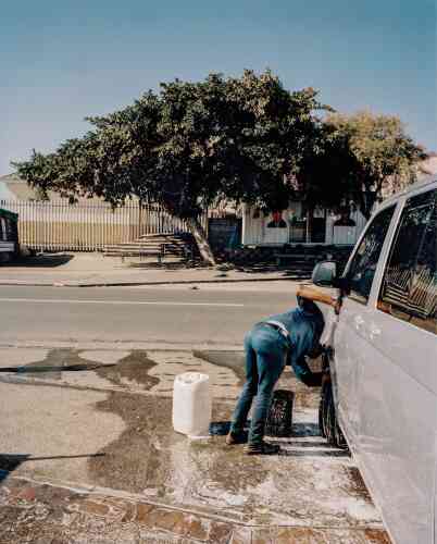 « Tyson’s Car Wash, township de Gugulethu. Le Cap, Afrique du Sud, 2018. » Un employé de l’entreprise Tyson’s Car Wash nettoie un camion. Il utilise deux seaux d’eau de 25 litres, un pour laver le véhicule et l’autre pour le rincer.